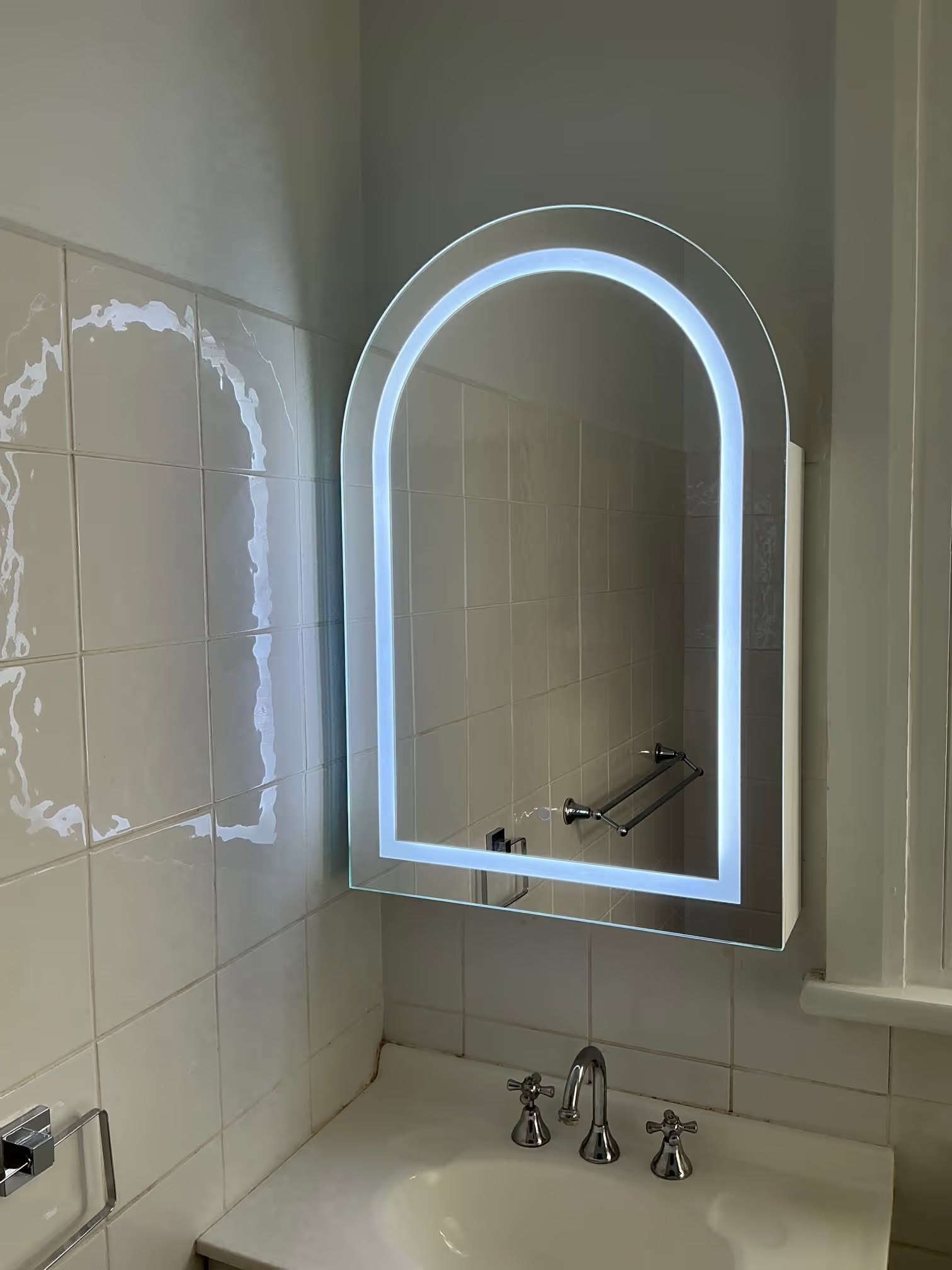 The same arch LED backlit bathroom mirror lit up, wired in by H1 Electrical & Air in Cowra