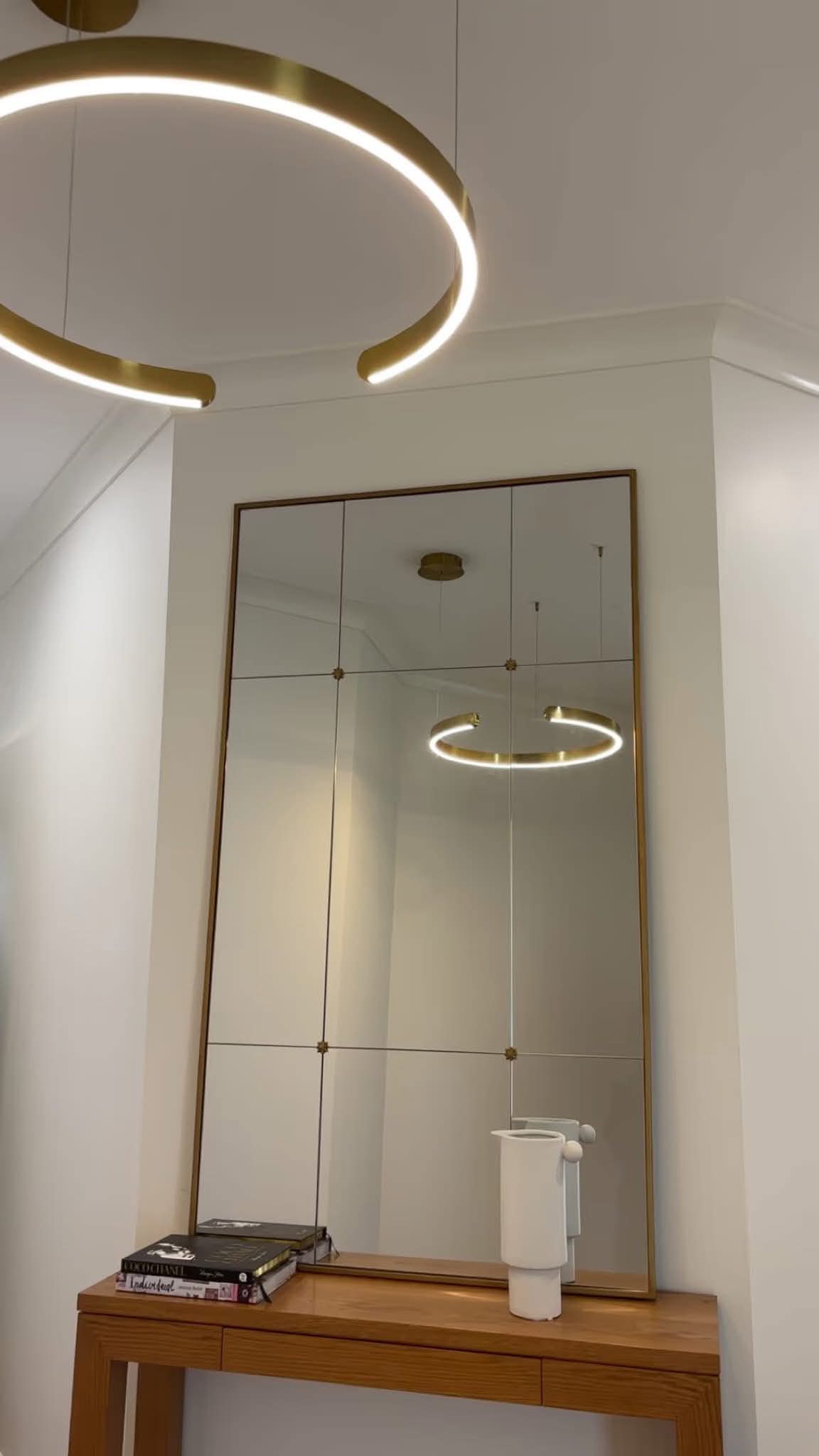 Designer gold LED ring pendant feature light installed over a hallway console by H1 Electrical & Air near Cowra