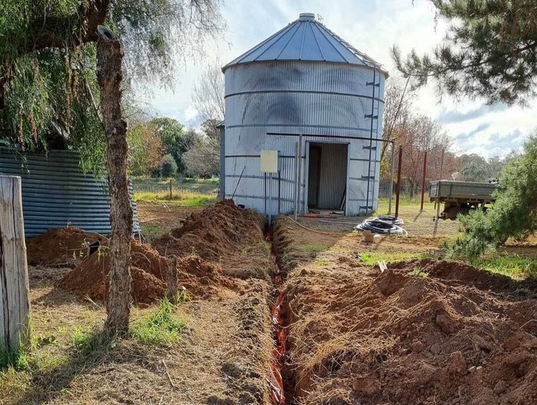 Trenched underground cable run out to a grain silo shed on a rural property near Cowra by H1 Electrical & Air